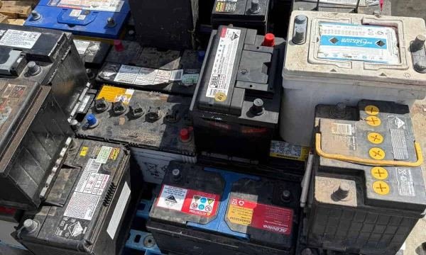 Used car batteries stacked for recycling at the yard