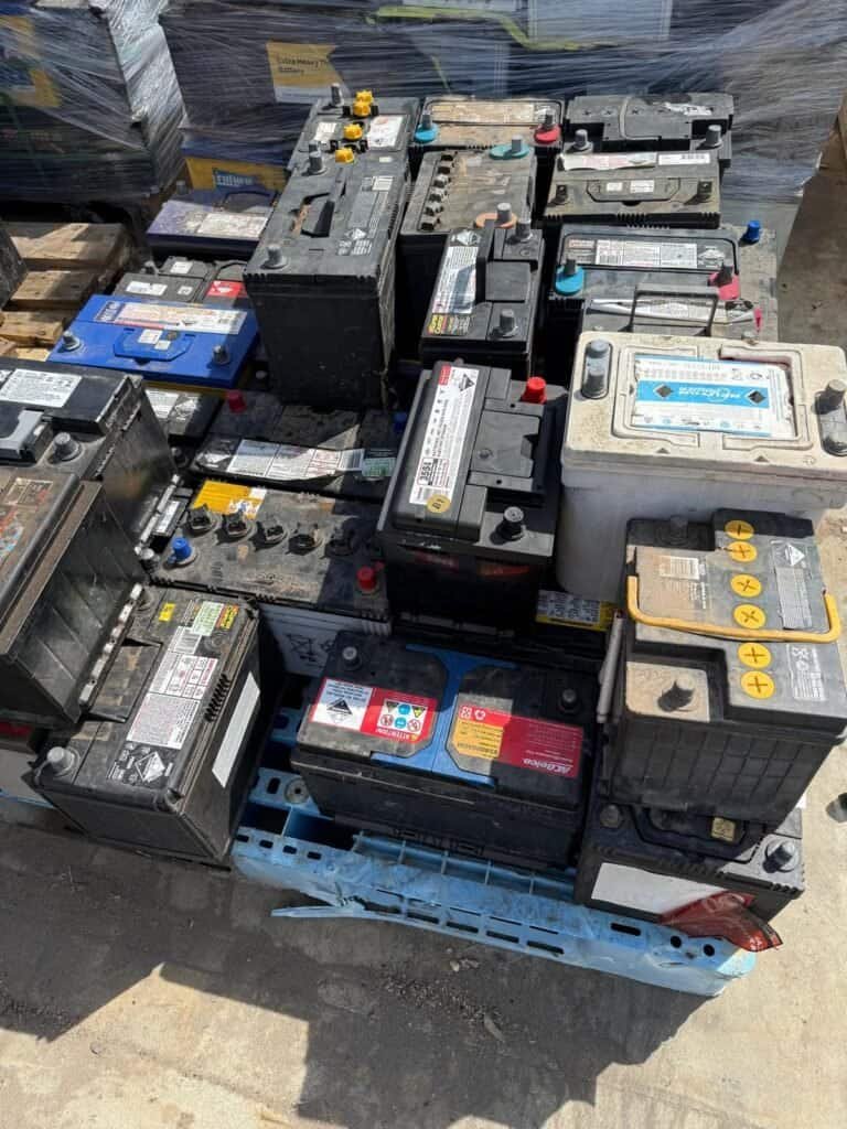 Used car batteries stacked for recycling at the yard