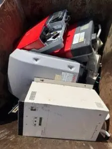 Used car batteries and UPS units in a scrap bin at Green Fields